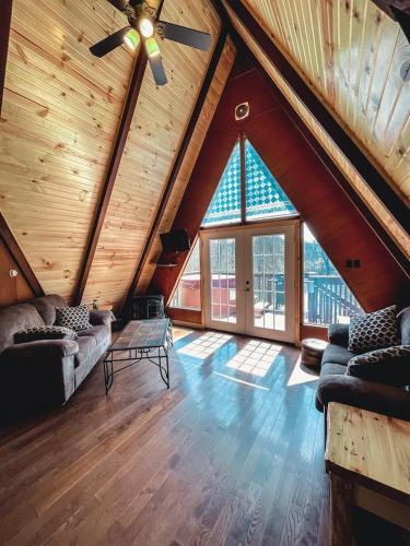 a living room with a ceiling fan and a large window at Edgewater Escape, Hocking Hills, Hot Tub, Pond in Rockbridge
