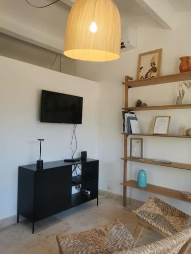 a living room with a flat screen tv on the wall at L'Atelier de Maison VB in Le Beausset