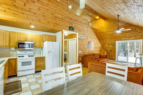 a kitchen and living room with a table and chairs at Less Than 1 Mi to ATV Trails Cadillac Golf Retreat! in Cadillac