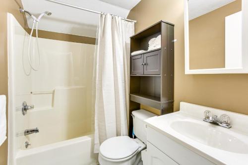 a bathroom with a white toilet and a sink at Less Than 1 Mi to ATV Trails Cadillac Golf Retreat! in Cadillac