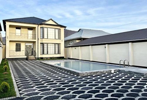 a house with a swimming pool in front of a house at Gabala Double Villas in Gabala