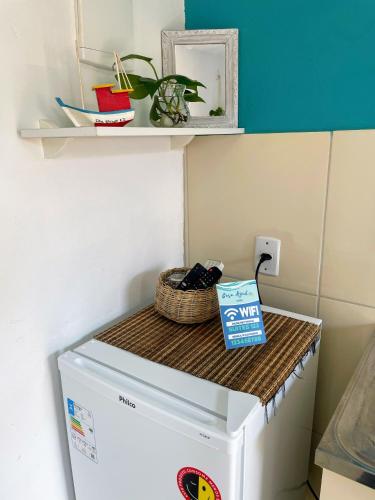 a white refrigerator with a basket on top of it at Suites Casa Azul-Vila do Abraão- conforto, limpeza, ótima localização in Abraão