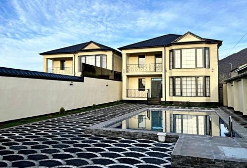 a large house with a swimming pool in front of it at Gabala Double Villas in Gabala
