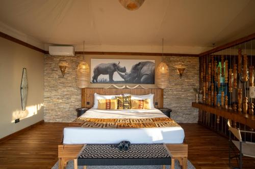 a bedroom with a large bed and a brick wall at Pearl Mara in Masai Mara