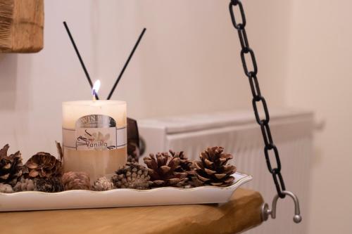 a candle and some pine cones on a table at Sokaki Guesthouse in Arachova