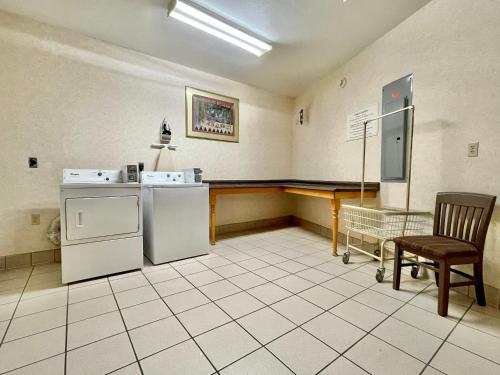 a room with a kitchen with a stove and a chair at FairBridge Inn & Suites Fort Wayne in Fort Wayne