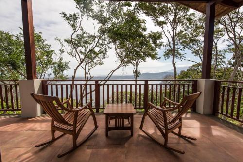 a patio with two chairs and a table on a deck at Pacaya Lodge and Spa in La Laguna