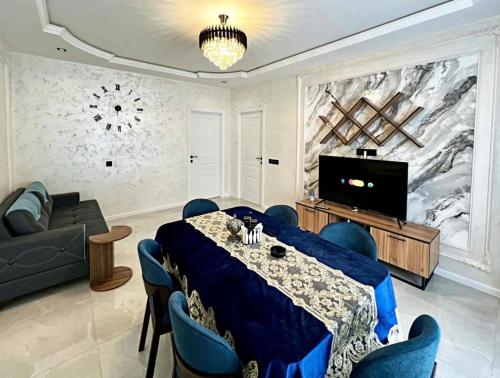 a living room with a table and a tv at Gabala Double Villas in Gabala