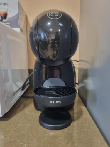 a black coffee maker sitting next to a microwave at VUT EL Mogollón in Guadalajara