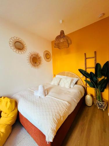 une chambre avec un lit aux murs jaunes dans l'établissement Studio rénové climatisé tout confort - Lit Queen size - emplacement idéal près des plages, à Nice