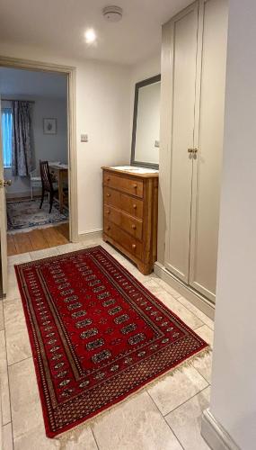 a room with a dresser and a red rug at THE ASH TREE - Charming & comfortable apartment in Frome