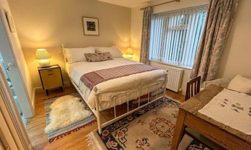 a bedroom with a bed and a table and a window at THE ASH TREE - Charming & comfortable apartment in Frome