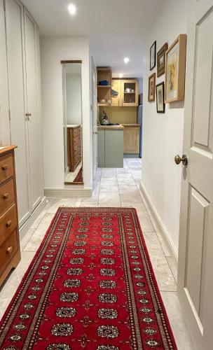 a hallway with a red rug on the floor at THE ASH TREE - Charming & comfortable apartment in Frome