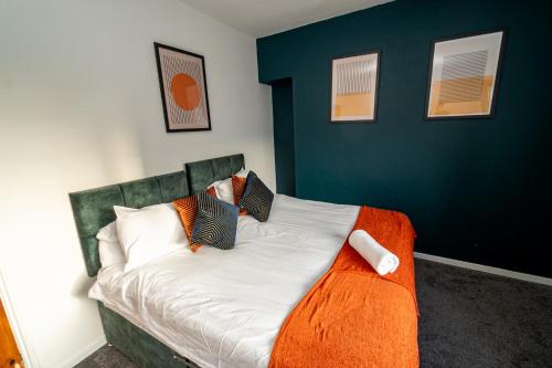 a bedroom with a bed with a blue wall at Stylish 3-Bed Swansea Home with WiFi & Kitchen in Swansea