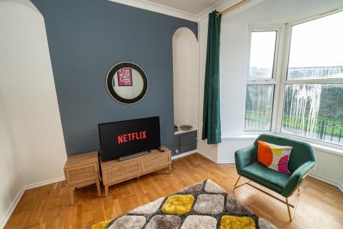 a living room with a tv and a chair at Stylish 3-Bed Swansea Home with WiFi & Kitchen in Swansea