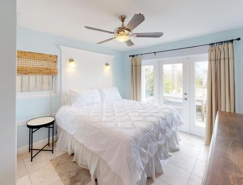 a bedroom with a bed and a ceiling fan at BEST BEACH Cottage Two Gorgeous Ocean Views - Renovated Like POTTERY BARN - Beach Steps Away in Saint Augustine Beach