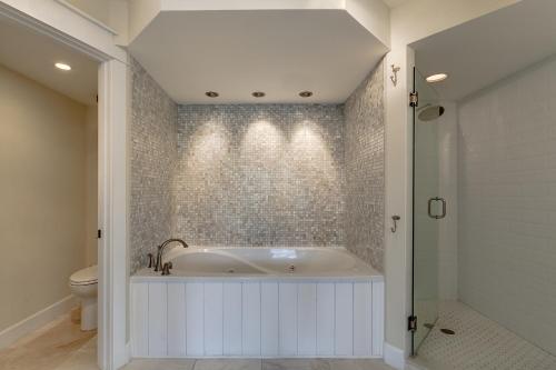 a white bathroom with a tub and a toilet at BEST BEACH Cottage Two Gorgeous Ocean Views - Renovated Like POTTERY BARN - Beach Steps Away in Saint Augustine Beach