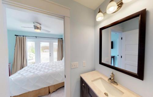 a bathroom with a bed and a mirror at BEST BEACH Cottage Two Gorgeous Ocean Views - Renovated Like POTTERY BARN - Beach Steps Away in Saint Augustine Beach