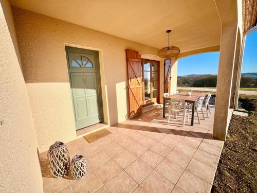 a porch of a house with a table and chairs at Les vallons de Gascogne in Bazian