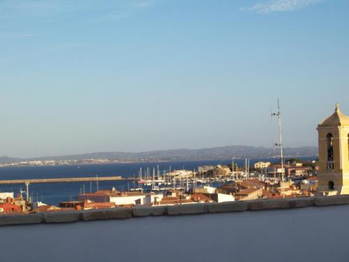 a city with a clock tower and a harbor at Hotel Villa Pimpina in Carloforte
