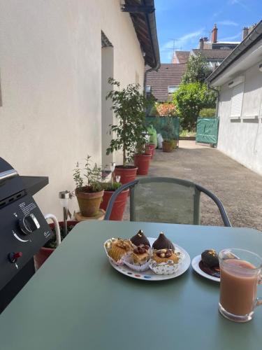 une table avec deux assiettes de nourriture et une boisson dans l'établissement Maison cosy centre-ville, à Luxeuil-les-Bains