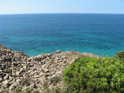 a large group of rocks and the blue ocean at Hotel Villa Pimpina in Carloforte
