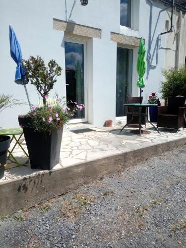 une maison avec un patio avec une table et un parasol dans l'établissement Bord de vilaine, à Nivillac