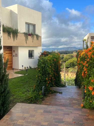 a house with a garden and a brick walkway at Casa Carolina - This One in Higuerón with Quality and Peace in Mijas