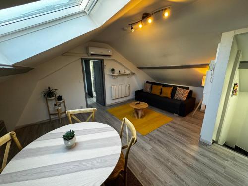un salon avec une table et un canapé dans l'établissement Chez Antonella centre Reims, à Reims
