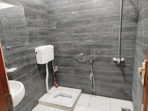 a bathroom with a toilet and a shower at The Warmer House Islamabad Airport in Islamabad