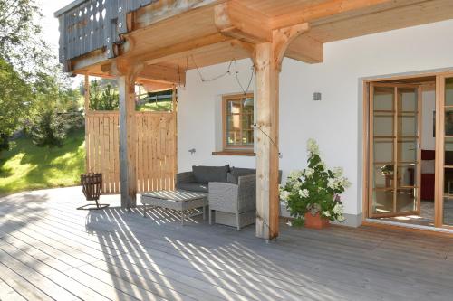 a wooden pergola with a couch on a deck at Ferienwohnung am Nettenbach in Bernau im Schwarzwald