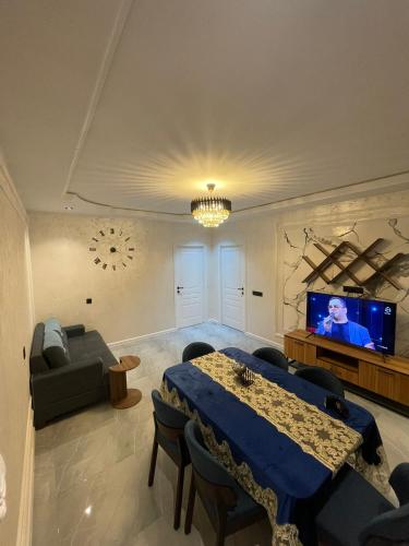a living room with a table and a flat screen tv at Gabala Double Villas in Gabala