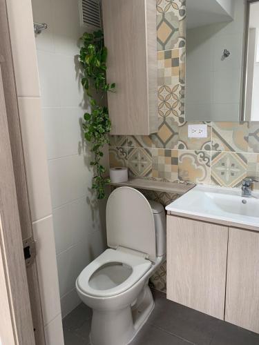 a bathroom with a toilet and a sink at Apartamento acogedor con vista a la naturaleza in Floridablanca