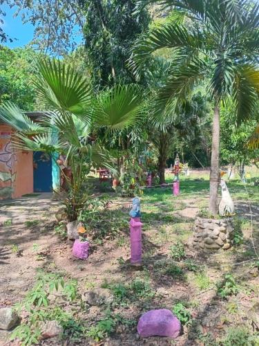 a garden with palm trees and colorful statues at Cabaña de Lucas in Loma Bonita