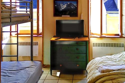 - une chambre avec une télévision sur une commode et un lit dans l'établissement Studio avec vue sur montagne à Luz-Saint-Sauveur, 32m² + terrasse, à Luz-Saint-Sauveur