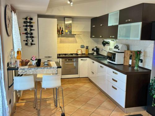 a kitchen with white cabinets and a table and chairs at Attico Belvedere - metro C e posto auto in Rome