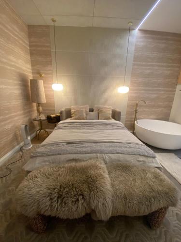une chambre avec un lit avec une baignoire et un tapis de bain dans l'établissement Large Boheme creative flat below Montmartre, à Paris