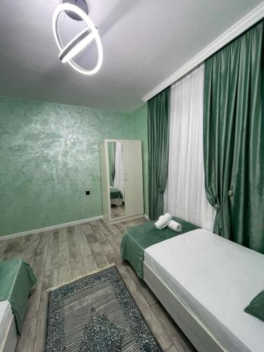 a bedroom with two beds and a mirror and a chandelier at Gabala Double Villas in Gabala
