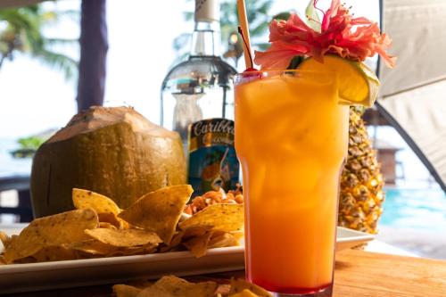 a plate of nachos and a drink on a table at Belizean Dreams Resort in Hopkins