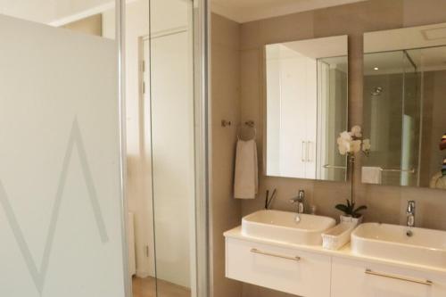 a bathroom with two sinks and a mirror at Condo in Sandton Masingita Tower in Johannesburg