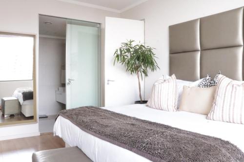 a bedroom with a large bed with a large mirror at Condo in Sandton Masingita Tower in Johannesburg
