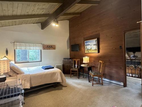 a bedroom with a bed and a desk in a room at Culps Cascade | Wi-Fi, Woodstove, Cedar Hot tub in Packwood