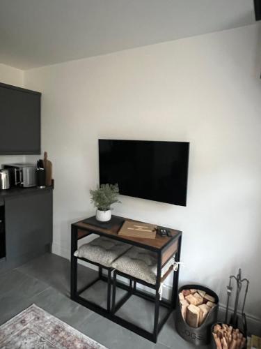 a living room with a table and a flat screen tv at The Hideaway - Free Street Parking in Swansea