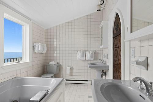 a bathroom with a tub and a sink and a toilet at Capacious North Truro Beachfront Home in Provincetown