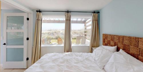 a bedroom with a white bed and a window at Cottage Four DIRECT OCEANFRONT Romantic Cottage Best Beach - Walk to Restaurants - Downtown only 5 Miles in Saint Augustine Beach