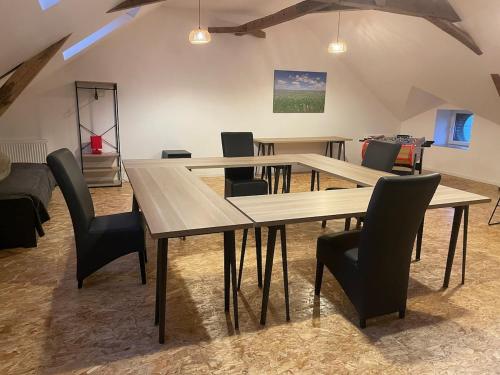 une salle à manger avec deux tables et des chaises noires dans l'établissement La Grisolle de 4 à 14 personnes, à Landouzy-la-Cour