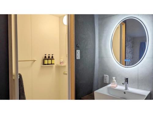 une salle de bain avec un lavabo et un miroir dans l'établissement Yonagunijima Hotel Munbu Stay Kukomae - Vacation STAY 93720v, à Sonai