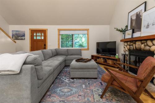 a living room with a gray couch and a tv at Alpine Drift in Packwood