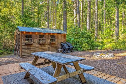 a picnic table and a cabin in the woods at Alpine Drift in Packwood