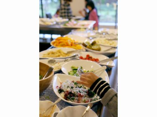 una persona comiendo comida en una mesa con platos de comida en The Paradise Garden Sasebo - Vacation STAY 03127v, en Sasebo